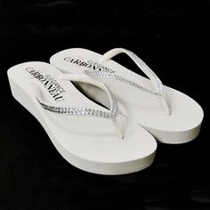 White Low Heel Wedge Bridal Flip Flops with Crystal StrapsThese low wedge special occasion and bridal flip flops feature a double row of sparkling crystals. This popular flip flop is the perfect accessory for the bride who is looking for a comfortable yet trendy alternative to wedding shoes. Whether worn to a destination wedding or changed into for the reception, you'll have happy feet!The flip flops feature a 1.25" heel with a .75" front platform.Color: White/Silver.Style: Sunshinewh.Available Bridal Wedges, Bridal Flip Flops, Beach Wedding Sandals, Wedding Flip Flops, Womens Low Heels, Heeled Flip Flops, Low Heel Wedges, White Wedges, Rubber Sandals