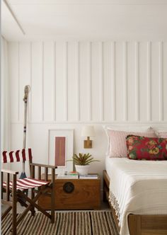 a bed sitting next to a wooden dresser in a bedroom on top of a rug