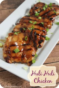 chicken with sauce and green onions on a white plate