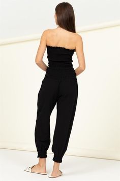 ONLINE EXCLUSIVE Elevate your style game with our Let Love Smocked Top and Trousers Set. The top boasts a flattering straight neckline and a tube silhouette, while the all-over smocked bodice adds a touch of chic texture. Tight ruffle details on the neck and hem add a playful twist to this fashionable ensemble. Paired with the smocked high-waist trousers, which cinch at the bottom cuffs for a tapered look, this set is the perfect combination of comfort and style. Imported. Designed in the USAMod Casual Non-stretch Strapless Tube Top, Trendy Smocked Bandeau Tube Top, Trendy Bandeau Tube Top With Smocked Bodice, Casual Cotton Tube Top With Smocked Bodice, Casual Non-stretch Smocked Top With Smocked Back, Casual Non-stretch Smocked Top, Casual Non-stretch Tube Top For Summer, Non-stretch Casual Tube Top For Summer, Casual Non-stretch Summer Tube Top