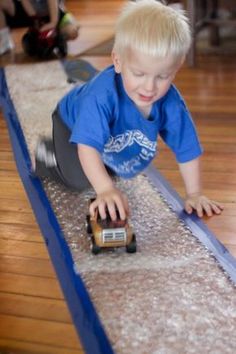 a young boy playing with a toy truck on the floor