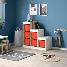 a child's playroom with blue walls and wooden furniture, including toys on the floor