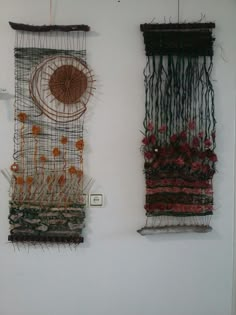 two wall hangings made out of wire and yarn with flowers in the middle one has a sun on it