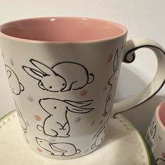 two coffee cups and saucers with designs on them