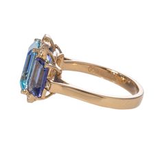 Goshwara 'Gossip' 3 Stone Blue Topaz and Tanzanite Emerald-Cut Ring with Diamonds in 18K Yellow Gold Total Blue Topaz Weight: 3.86 ct Total Tanzanite Weight: 2.29 ct Total Diamond Weight: 0.14 ct Color: G-H Clarity: VS Ring Size: 7 Formal Fusion Style Sapphire Ring, Formal Emerald Cut Multi-stone Topaz Ring, Formal Yellow Gold Gemstones With Blue Topaz, Elegant Sapphire Multi-stone Topaz Ring, Formal Tanzanite Ring In Fine Jewelry Style, Multi-stone Blue Topaz Ring For Formal Occasions, Blue Topaz Multi-stone Ring For Formal Occasions, Formal Sapphire Multi-stone Topaz Ring, Formal Multi-stone Blue Topaz Ring