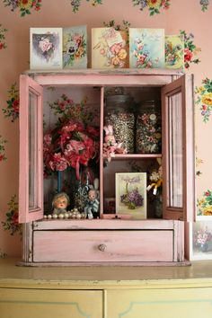 a pink cabinet with flowers and pictures on it