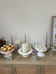 an assortment of cakes and cupcakes on a table