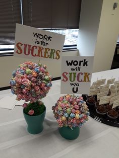 two vases filled with cupcakes sitting on top of a table