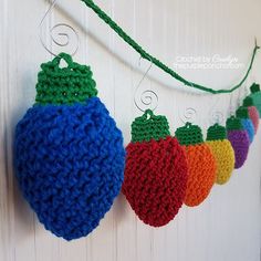 crocheted christmas ornaments hanging from a line on a white wall with green string