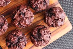 several chocolate muffins on a wooden cutting board