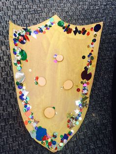 a wooden board with lots of different colored beads on it's sides and holes in the middle