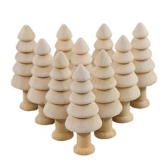 small wooden christmas trees are lined up in a row on a white background, with one standing out from the crowd