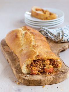 there is a large piece of bread that has meat in it on a cutting board