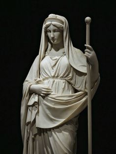 a statue of the virgin mary holding a staff