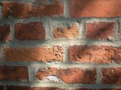 a brick wall that has been made with red bricks and mortared in to it