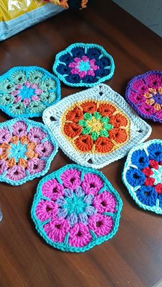 six crocheted coasters are arranged on a table