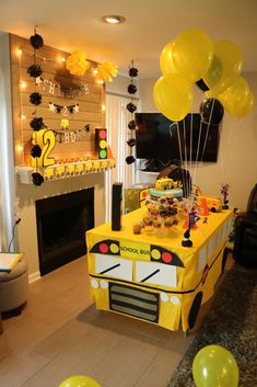 a school bus themed birthday party with balloons and streamers on the ceiling, in front of a fireplace