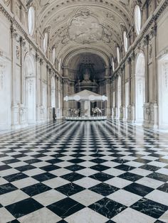 an ornately decorated hall with black and white checkered flooring is featured in this image