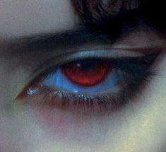 an eye with red and blue colors is seen through the lens of someone's eye