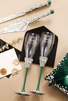 two green wine glasses sitting on top of a table next to other items and decorations