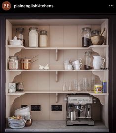 the shelves in this kitchen are filled with dishes and coffee maker, cups, and other items