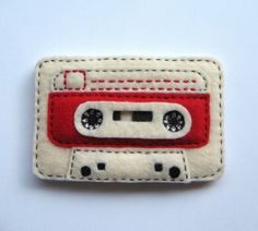 a red and white patch with a cassette on it