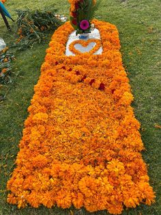 an arrangement of flowers is laid out on the grass to be used as a memorial