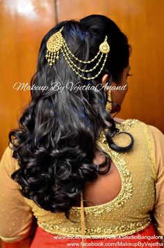 a woman with long black hair wearing a gold headpiece