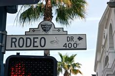 a street sign on rodeo drive with palm trees in the background