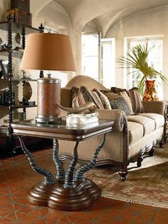 a living room filled with lots of furniture and decor on top of a red tile floor