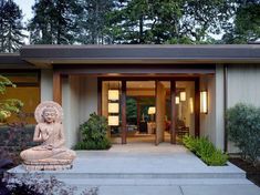 a buddha statue sitting in front of a house