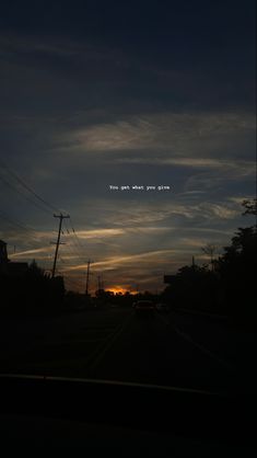 the sun is setting behind some power lines and telephone poles with an airplane in the sky