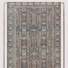 a blue and beige rug with an intricate design on the bottom, in front of a gray background