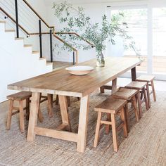 a wooden table sitting under a stair case