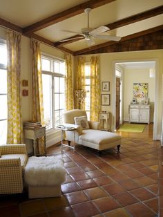 a living room filled with furniture and yellow curtains