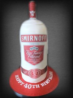 a birthday cake made to look like a bottle of smirnoff liquor on top of a red coaster