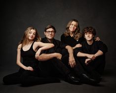 a group of people sitting on the ground posing for a photo