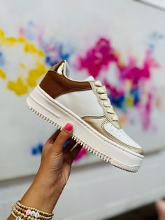 We are so in love with these sneakers! The Logan Sneaker features a tan/gold color, cushioned insole and platform sole. These are perfect to style with any outfit! Color: Tan White Laces Cushioned insole Platform sole Runs true to size. Fall Candle Decor, Tan Sneakers, Athletic Skirts, Antique Candles, Kids Beanies, Bowl Fillers, So In Love, Lantern Candle Holders, Purse Pouch