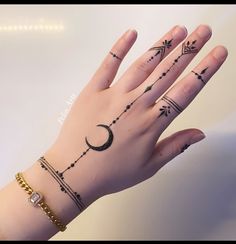 a woman's hand with tattoos on it and a crescent tattoo on the wrist