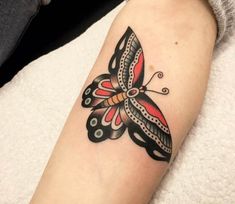 a colorful butterfly tattoo on the arm