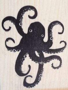 an octopus carved into wood with black ink