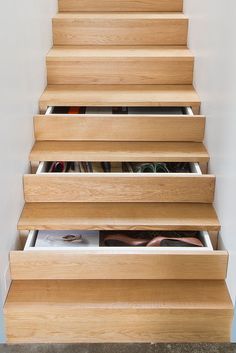 the stairs are made out of wood and have drawers under them for shoes or other items