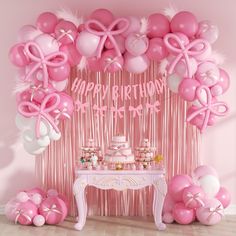 a pink birthday party with balloons, cake and streamers in the shape of bows