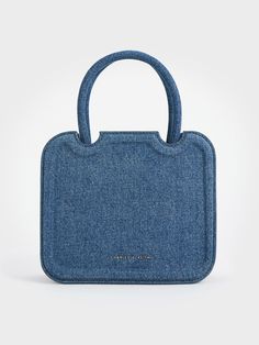 For a fresh and modern take on the everyday bag, look no further than this Perline sculptural tote bag in full denim. It features a boxy and structured silhouette, marked by clean lines and a minimal design, that will effortlessly complement casual and dressy outfits alike. The magnetic closure offers easy access to your belongings while the bag can be carried in multiple ways - hold it by the top handles, hang it on the crook of your arm, or sling it on your shoulders. Modern Denim Shoulder Bag For Everyday, Modern Everyday Denim Shoulder Bag, Modern Denim Blue Bag For Everyday Use, Trendy Top Handle Denim Bag, Chic Rectangular Denim Shoulder Bag, Everyday Denim Top Handle Bag, Chic Denim Blue Rectangular Shoulder Bag, Blue Denim Top Handle Shoulder Bag, Modern Blue Denim Shoulder Bag