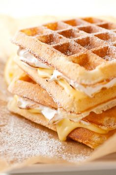 a stack of waffles sitting on top of a table covered in butter and syrup