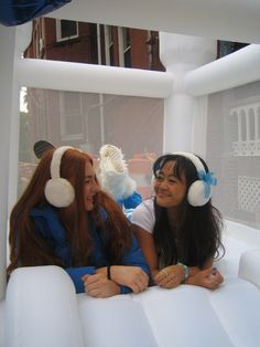 two women sitting on an inflatable float wearing headphones