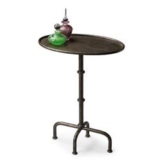 a small table with a green vase on it's top and a metal stand