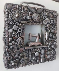 an old sewing machine is framed in a metal frame with buttons and other things on it