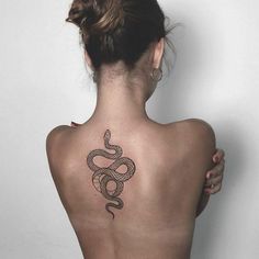 a woman with a snake tattoo on her back