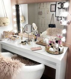 a white vanity with lights on it and a chair in front of the mirror next to it